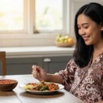 Seorang ibu hamil makan sambal dengan ekspresi wajah bahagia, menunjukkan cara menikmati makanan pedas yang aman selama kehamilan