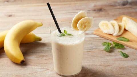 Segelas jus pisang yang kental dan berwarna krem. Pisang sangat kaya akan kalium, mineral penting untuk mengelola dan menurunkan tekanan darah tinggi saat hamil.