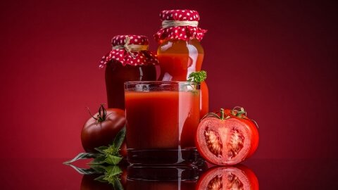 Jus tomat segar berwarna merah cerah disajikan dalam gelas. Jus tomat adalah sumber likopen dan kalium yang baik untuk menurunkan tekanan darah tinggi pada masa kehamilan.